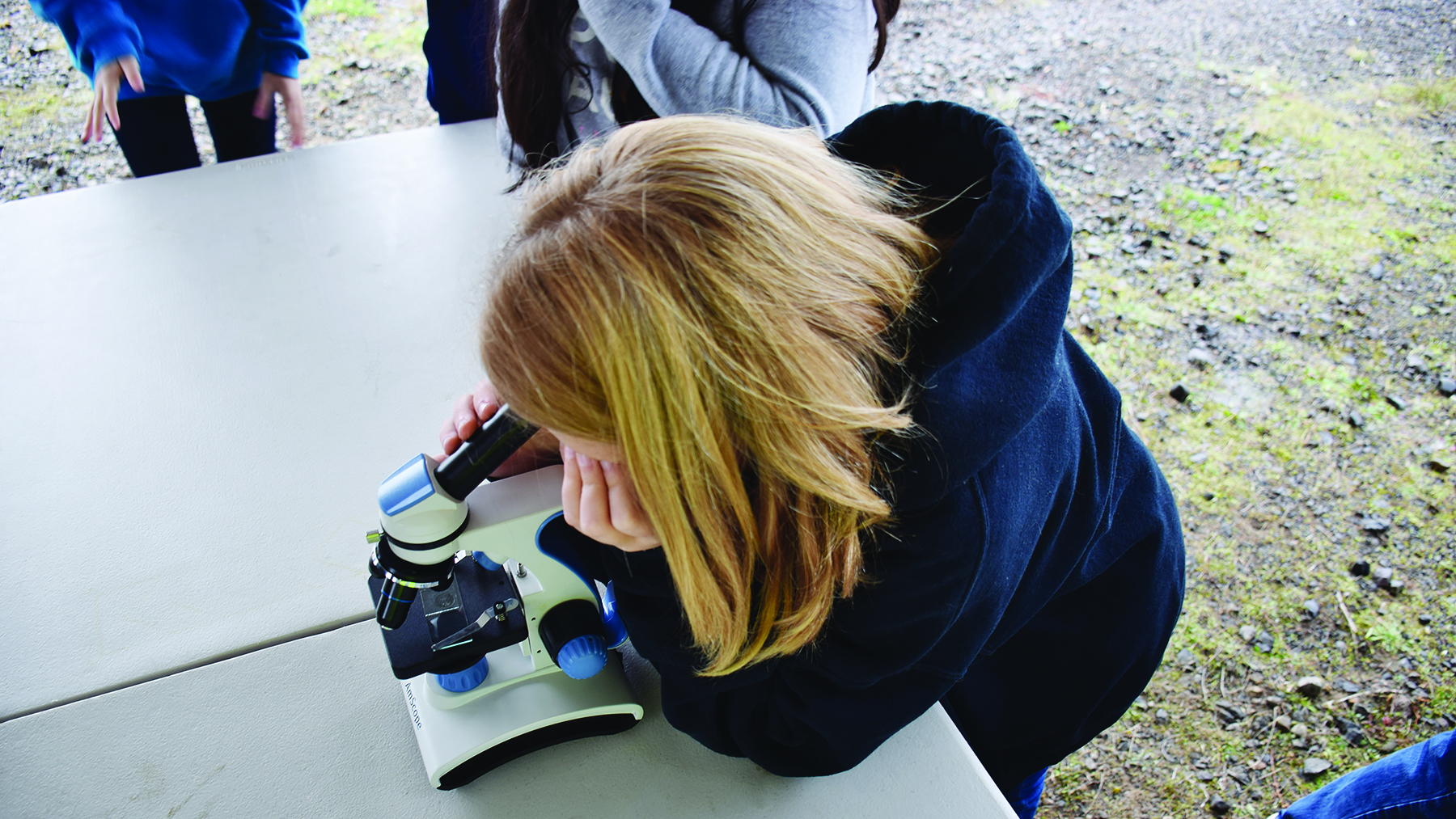Clean Water University girl looking into microscope